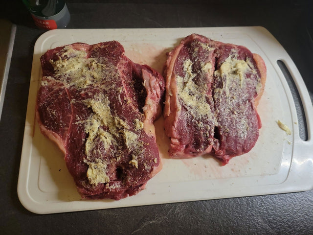 Customer review photo: two XL sirloin steaks with garlic butter on a chopping board